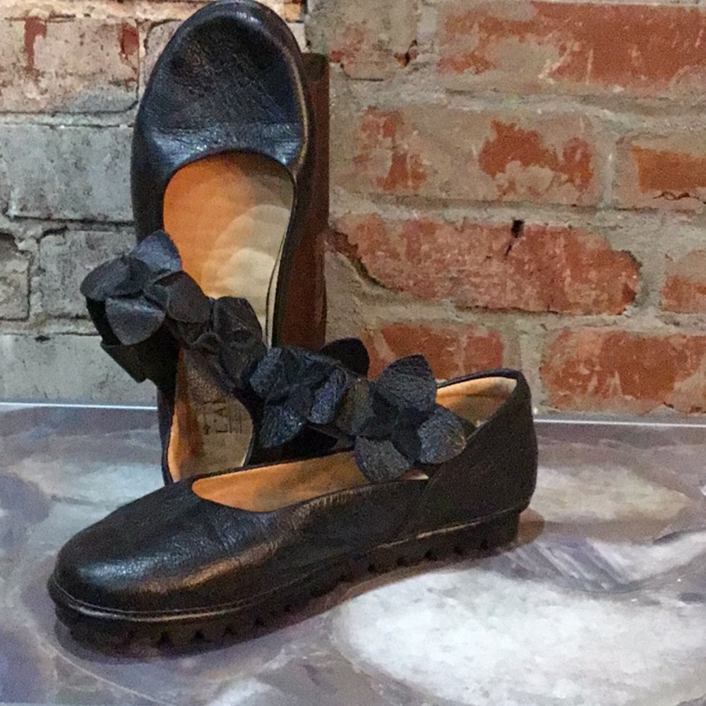 L’artiste black flats with floral ankle straps.